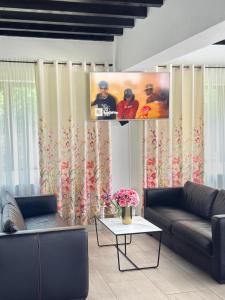 a living room with two couches and a table at Pensiunea Merişor in Răchiţele