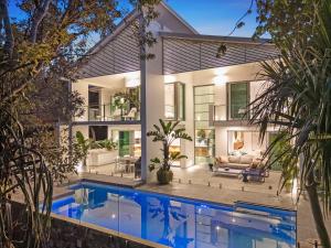 a house with a swimming pool in front of it at Luxe on North Point in Kingscliff