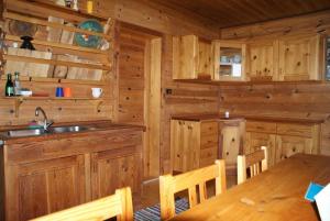 a kitchen with wooden cabinets and a table in a cabin at Fröschlhütte in Oberpirkach