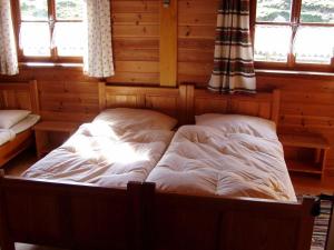 a bedroom with a bed in a room with windows at Fröschlhütte in Oberpirkach +4 photos