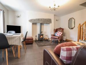 a living room with a table and a fireplace at Old Station Cottage in Blaenau-Ffestiniog