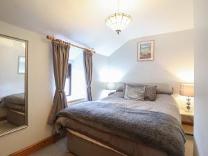 a bedroom with a bed and a mirror at Old Station Cottage in Blaenau-Ffestiniog