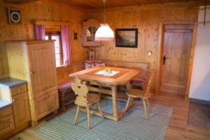 a dining room with a wooden table and chairs at Ferienhütte Windlegern in Neukirchen