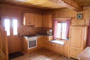 a kitchen with wooden cabinets and a window at Ferienhütte Windlegern in Neukirchen