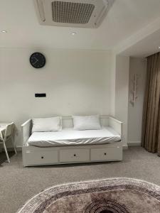 a white bed in a room with a clock on the wall at شقة رقم 1 in An Najaf