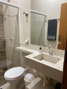 a bathroom with a sink and a toilet and a shower at Recanto dos Ipês a 4 min do Moinho in Holambra