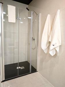 a shower in a bathroom with white towels at Quinta do Botas in Moimenta
