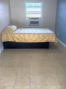 a small bed in a room with a window at Star Motel in Tampa