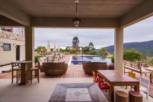 a patio with tables and chairs and a swimming pool at Solar Da Serra Tiradentes in Tiradentes