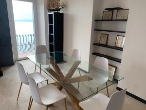 a glass dining room table with white chairs at HyggeWaves in Bogliasco +14 photos