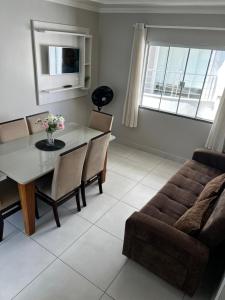 a living room with a table and a couch at Residencial Costa Marfim in Bombinhas