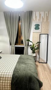 a bedroom with a bed with a green blanket on it at R&R Suite Heritage in León
