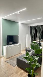 a living room with two beds and a flat screen tv at R&R Suite Heritage in León