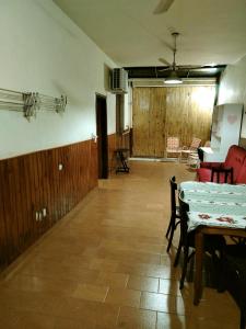 a room with a table and chairs and a room with wooden walls at Posada Familiar ELDORADO in Eldorado