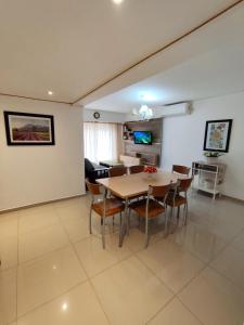 a dining room and living room with a table and chairs at Depto céntrico de 3 habitaciones y cochera in Rosario