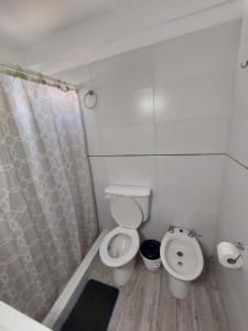a white bathroom with a toilet and a shower at Depto céntrico de 3 habitaciones y cochera in Rosario +18 photos