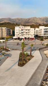 a parking lot with palm trees in a city at Hotel Divers in Vlorë