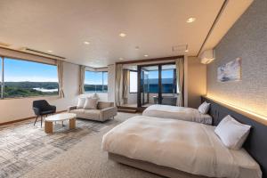 a hotel room with two beds and a chair at Ooedo Onsen Monogatari Premium Shima Saichoraku in Shima