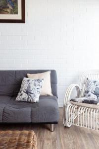 a living room with a blue couch and a chair at Shoalhaven Heads Motel in Shoalhaven Heads +21 photos