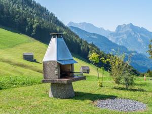 a stone bird feeder in a field with mountains in the background at Villa mit Seeblick in Amden