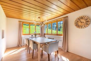 a dining room with a table and a clock on the wall at Villa mit Seeblick in Amden