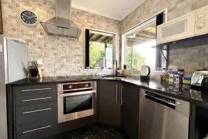 a kitchen with a sink and a refrigerator at Cosy Raglan Studio - Walk to Beach and Village - Roberts St - Studio Downstairs in Raglan