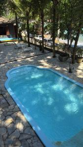a large blue swimming pool in a yard at Deck Picinguaba Pousada in Picinguaba