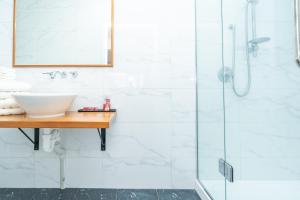 a bathroom with a sink and a shower at Cosy Raglan Studio - Walk to Beach and Village - Roberts St - Studio Downstairs in Raglan