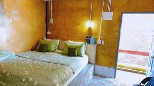 a bed with green pillows in a room at Banpu Beach Ao Lung Dam,Koh Samet in Ao Phutsa +45 photos