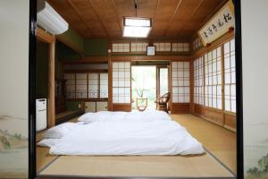 a large white bed in a room with windows at Guest House Ilonggo in Tsu +123 photos