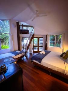 a bedroom with a large bed and a wooden floor at Ferntree Rainforest Lodge in Cape Tribulation