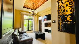 a living room with a leather couch and a window at Casa Grande Hotel Boutique in Comitán