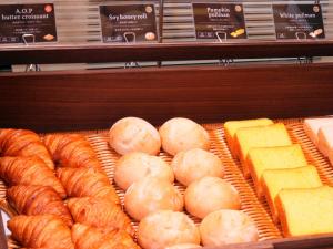 a display case in a bakery with bread and cheese at Asahikawa Sun Hotel in Asahikawa +50 photos