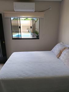 a bedroom with a white bed and a window at Espaço Real in Manhã