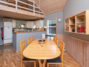a kitchen and dining room with a wooden table and chairs at 8 person holiday home in Læsø in Læsø +13 photos