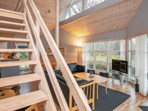 a living room with a wooden staircase in a house at 8 person holiday home in Læsø in Læsø