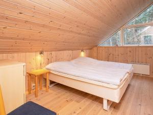 a bedroom with a bed in a wooden room at 8 person holiday home in Læsø in Læsø