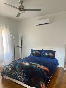 a bedroom with a bed and a ceiling fan at Island Time house in Utila