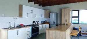 a kitchen with white cabinets and a stove top oven at Sunrise On Sea Backpackers in Port St. Johns