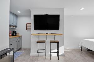a room with a table with two stools and a tv on a wall at The Briarcliff Suite studio in Athens