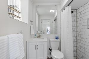 a white bathroom with a toilet and a sink at The Briarcliff Suite studio in Athens +7 photos
