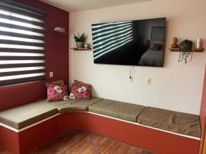 a couch in a room with a tv on the wall at Casa Sosa in Zacatlán