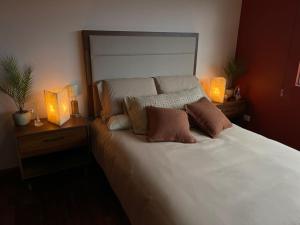 a bedroom with a white bed with two night stands and two lamps at Casa Sosa in Zacatlán