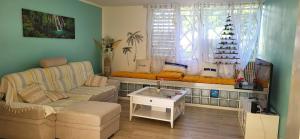 a living room with a couch and a table at Escale caraibe in Le Gosier +3 photos