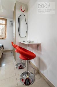 a red stool in a room with a mirror at Studio Centro - 7 Copas in Rio de Janeiro