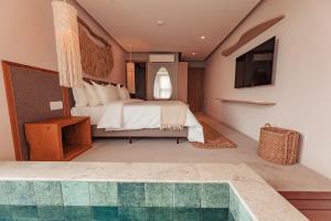a bedroom with a bed and a swimming pool at Pousada Aysú in Japaratinga