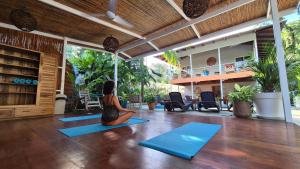 a woman sitting in a yoga position in a room at Sanctuary Puerto Viejo in Cocles