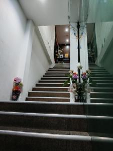 a stairway with stairs with flowers in vases at Cahaya Hanson BilikXpert in Kuala Lumpur