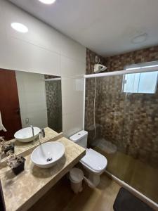 a bathroom with a sink and a toilet and a shower at Búzios Family House in Búzios +14 photos