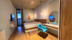 a small bedroom with a bed and a blue chair at Villa #40, Ambassadori Kachreti Golf Resort in Kachretʼi +65 photos